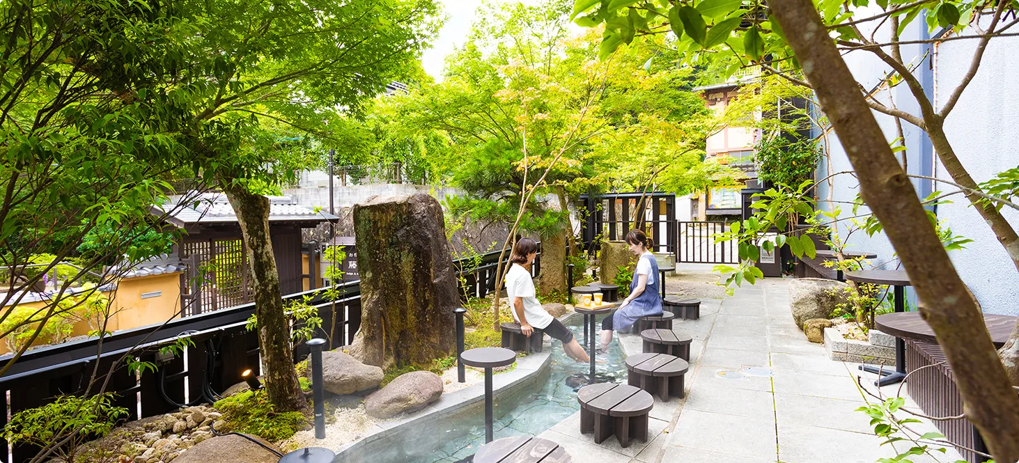 木々に囲まれた屋外の足湯とベンチ